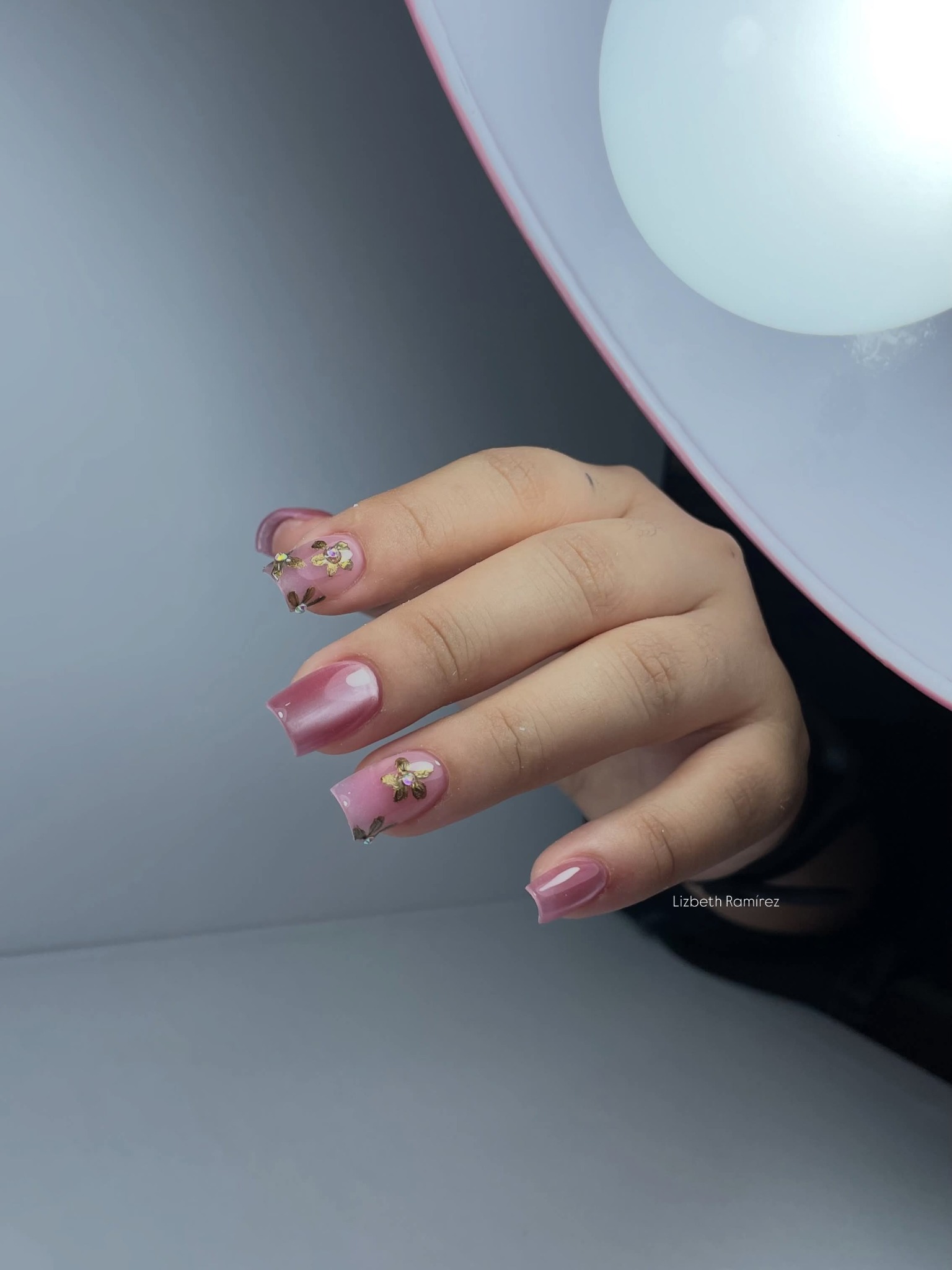 Uñas rosa degradado junto a esmaltes gel polish