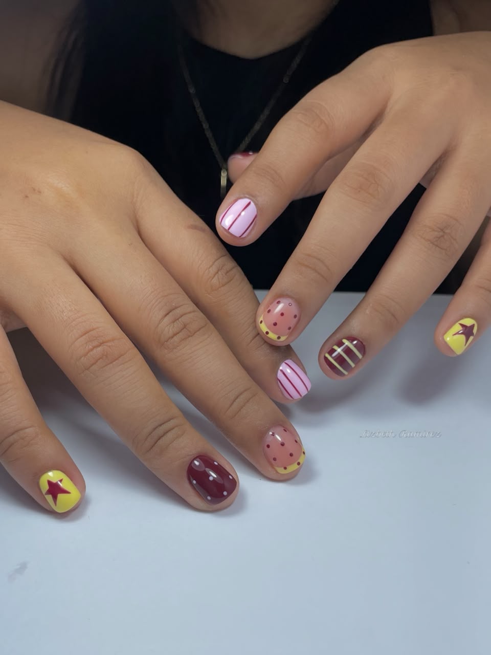 Uñas cortas con diseños de colores, estrellas y lunares