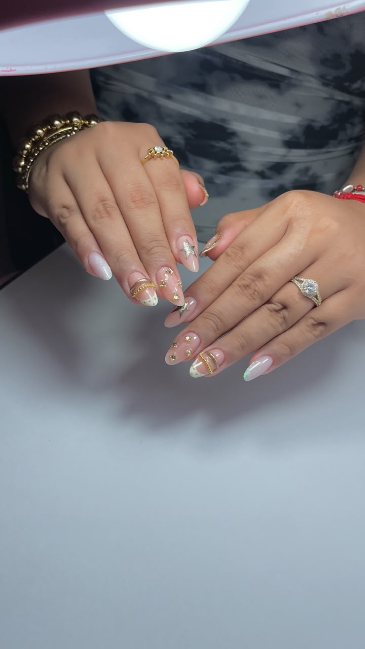 Uñas elegantes con estrellas, perlas y detalles dorados