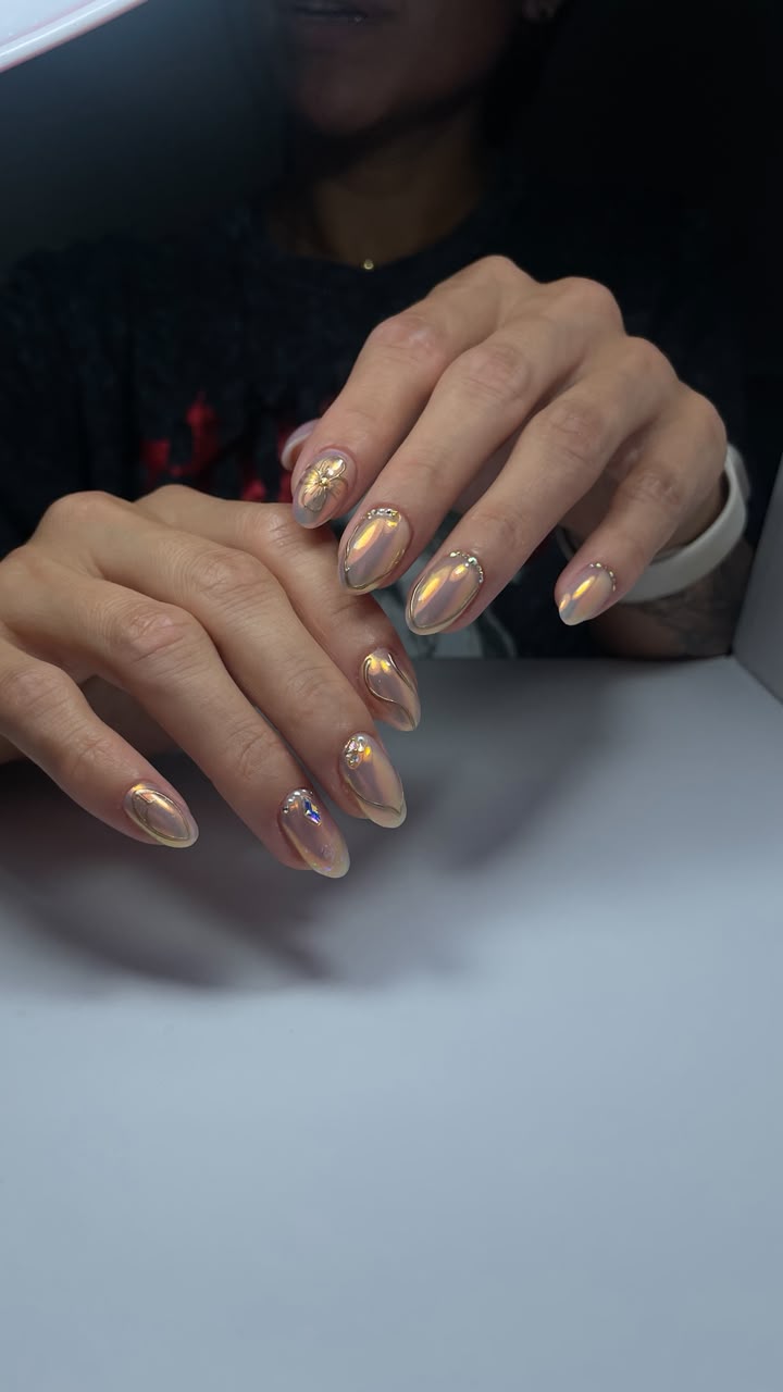 Uñas efecto cromado dorado con pedrería y flor